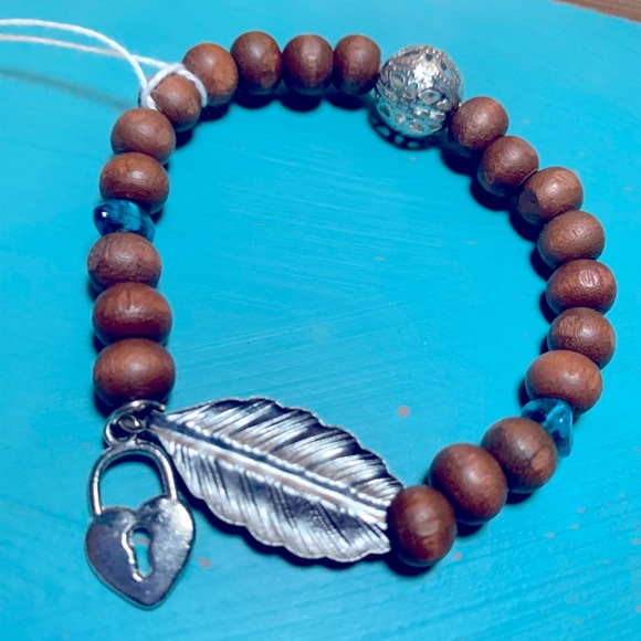 Wood bead bracelet with feather and heart lock. Stretchy one size boho vibe. - Picture 3 of 7